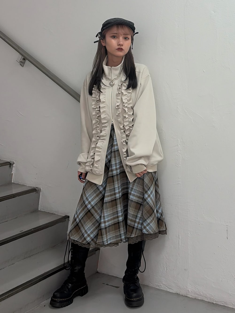 ホワイト系のジャージ、ブラウン系のスカート、グレー系のハンチング/ベレー帽を着用したレディースの冬コーディネートの4枚目の写真