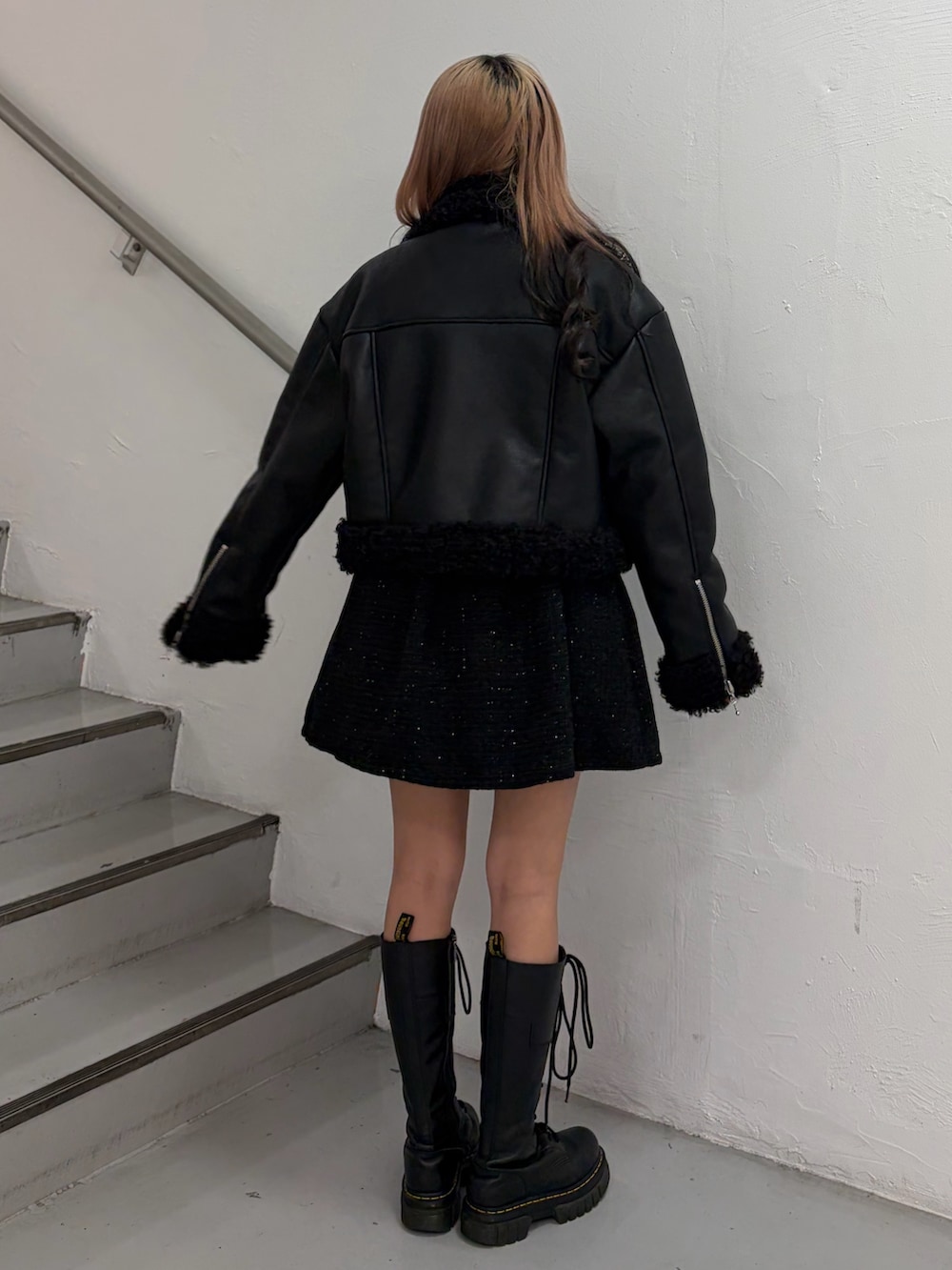 ブラック系のムートンコート、ブラック系のワンピース、レッド系のニット/セーターを着用したレディースの秋コーディネートの4枚目の写真