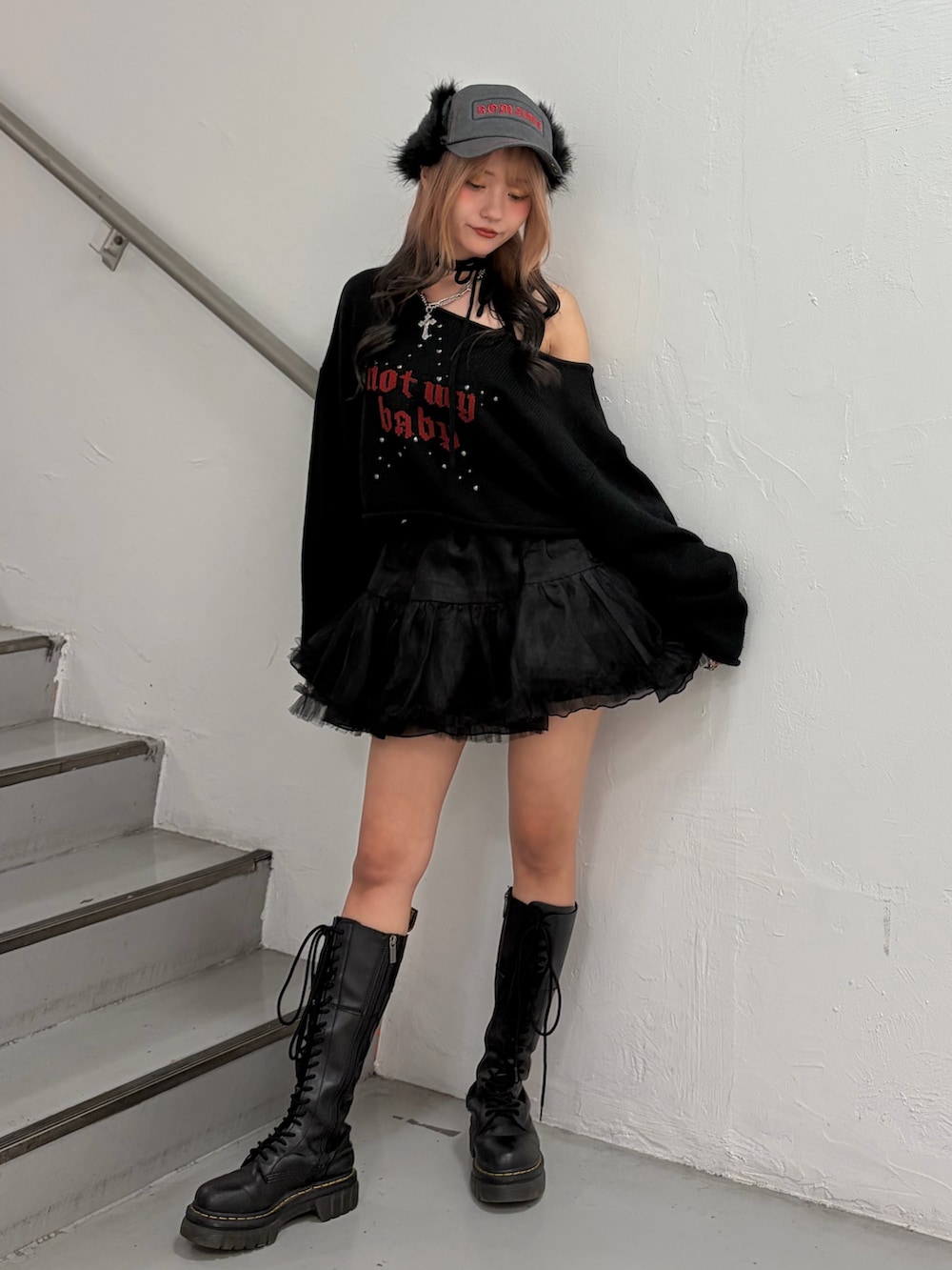 ブラック系のニット/セーター、ブラック系のスカート、ブラック系のキャップを着用したレディースの秋コーディネートの2枚目の写真