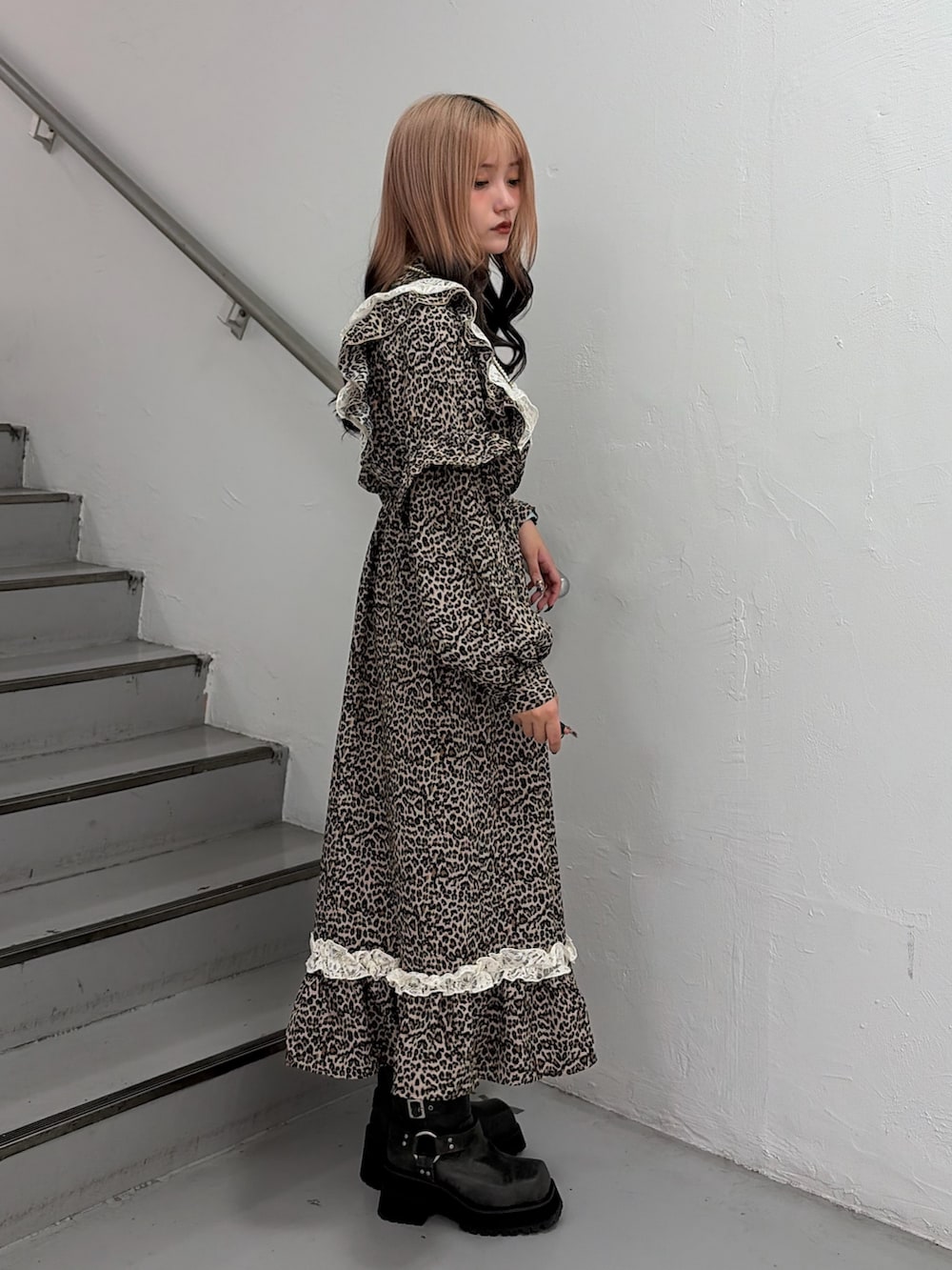 ブラウン系のワンピース、ブラック系のブーツ、ホワイト系のネックレスを着用したレディースの秋コーディネートの2枚目の写真