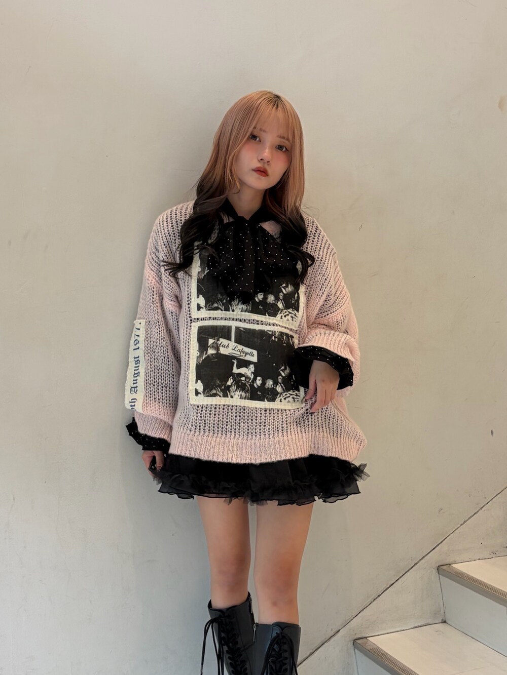 ピンク系のニット/セーター、ブラック系のスカート、ブラック系のシャツ/ブラウスを着用したレディースの秋コーディネートの5枚目の写真