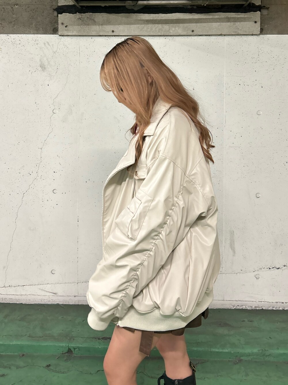 ホワイト系のブルゾン、レッド系のTシャツ/カットソー、ブラウン系のスカートを着用したレディースの秋コーディネートの5枚目の写真