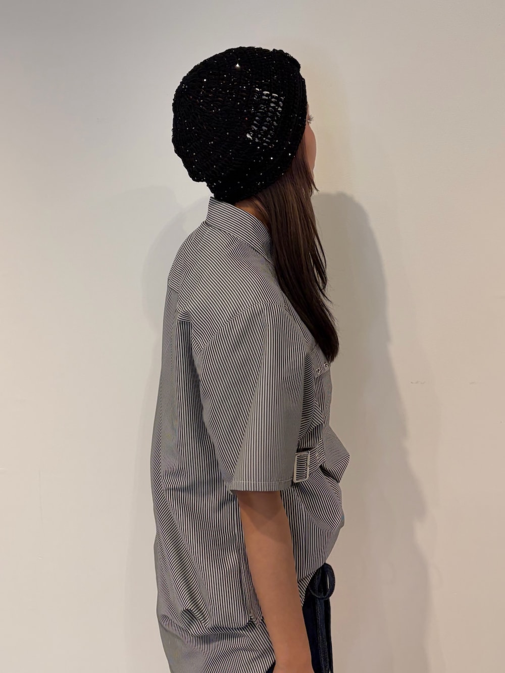 ブルー系のデニムパンツ、ブラック系のシャツ/ブラウス、ブラック系のニットキャップ/ビーニーを着用したレディースの春コーディネートの6枚目の写真
