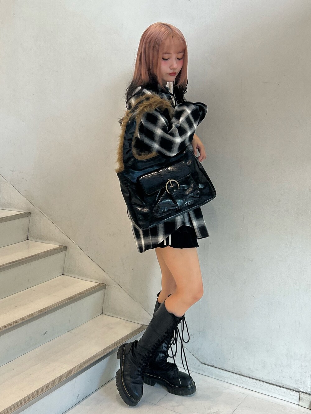 ブラック系のシャツ/ブラウス、ブラック系のスカート、ブラック系のハンドバッグを着用したレディースの秋コーディネートの3枚目の写真