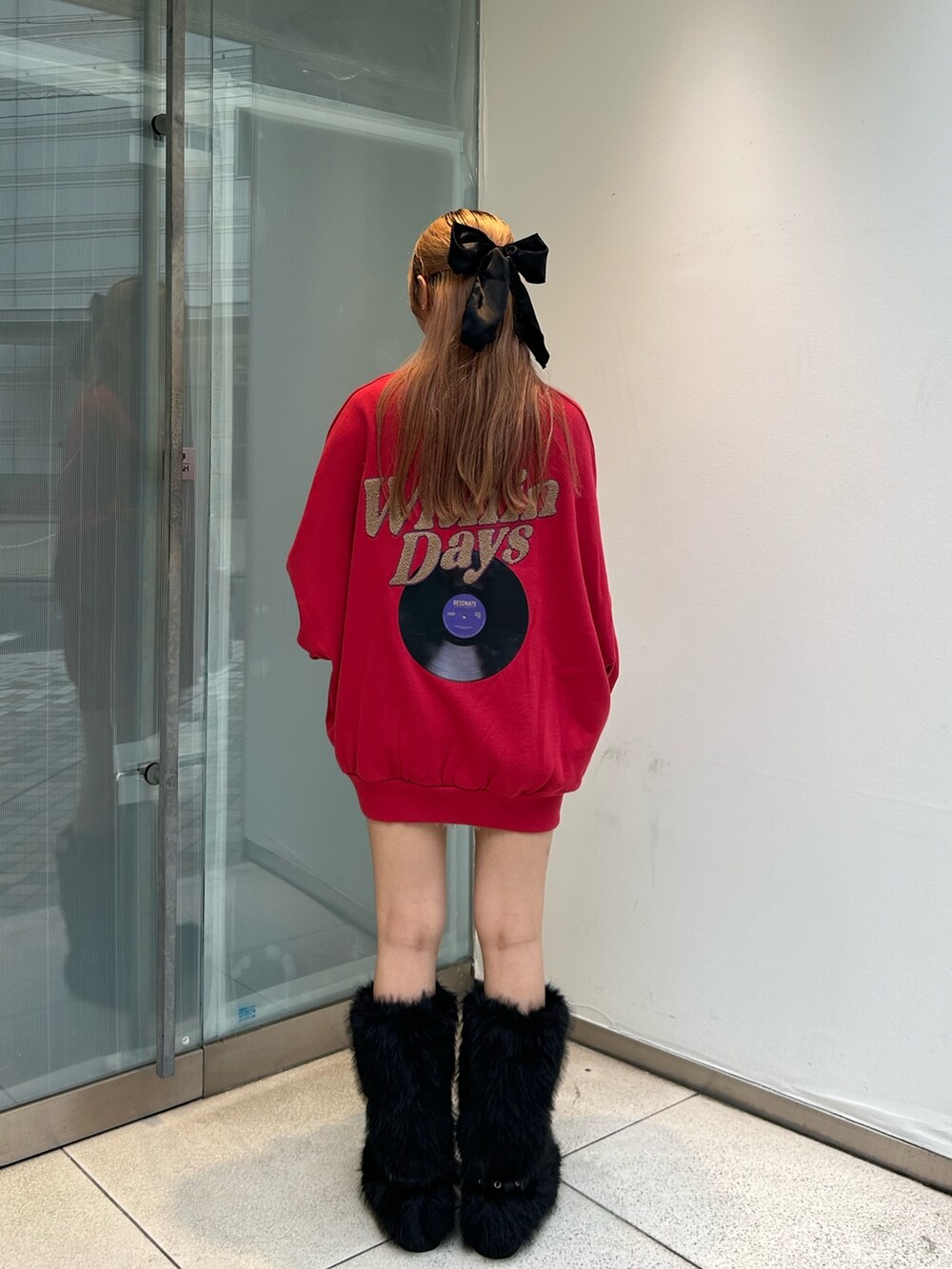 レッド系のTシャツ/カットソー、ブラック系のブーツ、ブラック系のアームカバーを着用したレディースの秋コーディネートの4枚目の写真