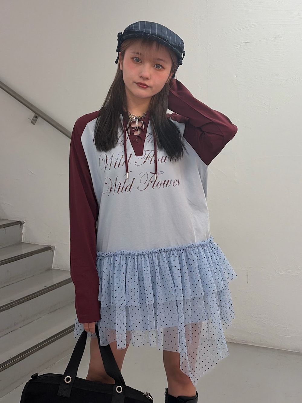 ブルー系のワンピース、ブラック系のボストンバッグ、グレー系のハンチング/ベレー帽を着用したレディースの冬コーディネートの5枚目の写真