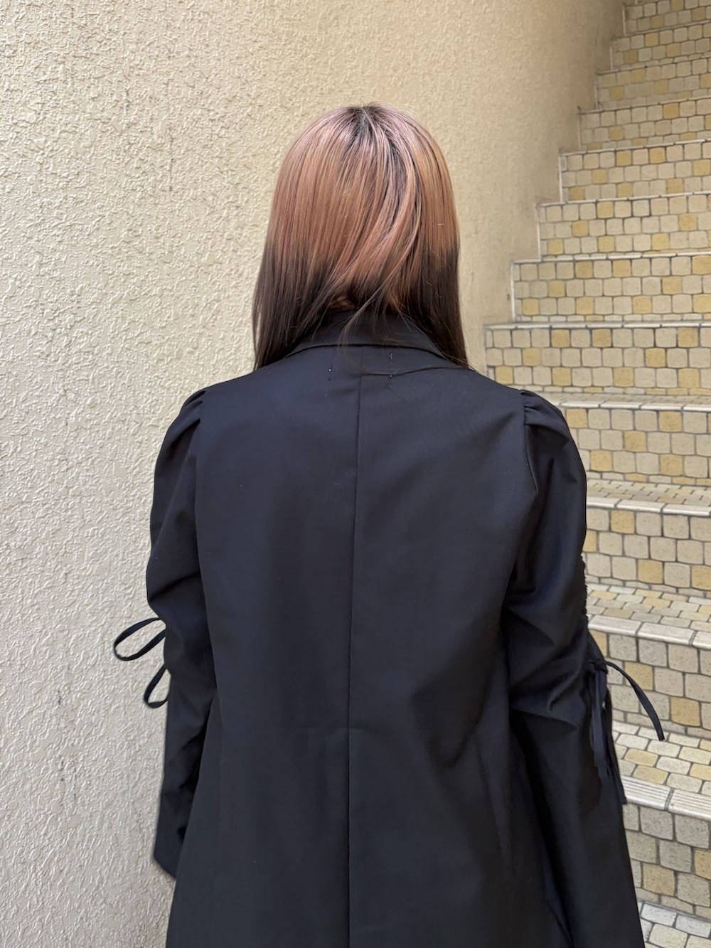 ブラック系のテーラードジャケット、ブラック系のその他パンツ、シルバー系のハンドバッグを着用したレディースの冬コーディネートの6枚目の写真