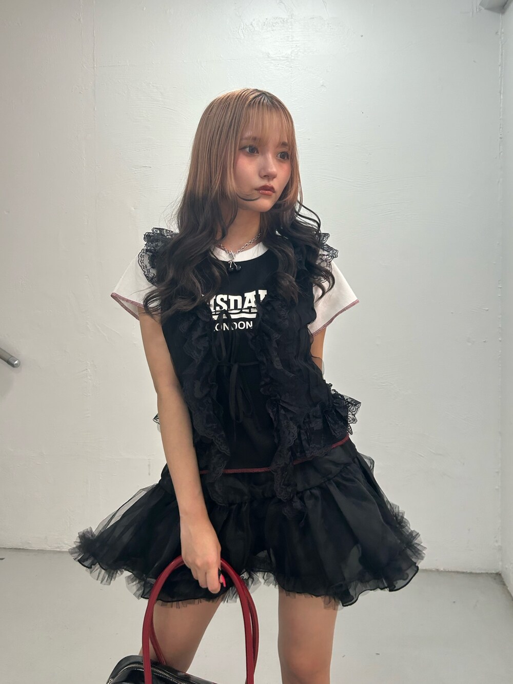 ブラック系のTシャツ/カットソー、ブラック系のスカート、ブラック系のボストンバッグを着用したレディースの夏コーディネートの4枚目の写真