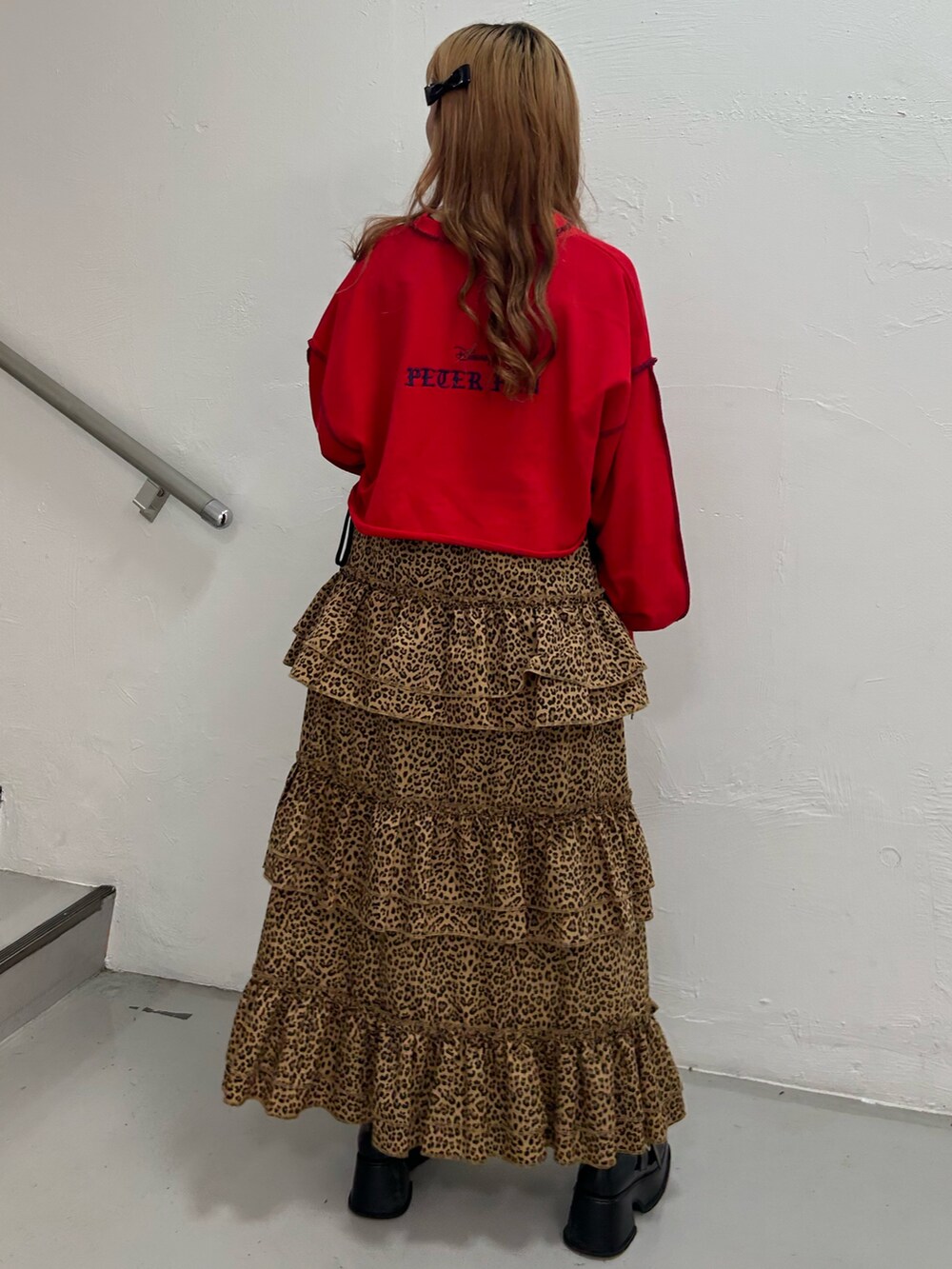 レッド系のスウェット、ブラウン系のスカート、ブラック系のバレエシューズを着用したレディースの夏コーディネートの2枚目の写真