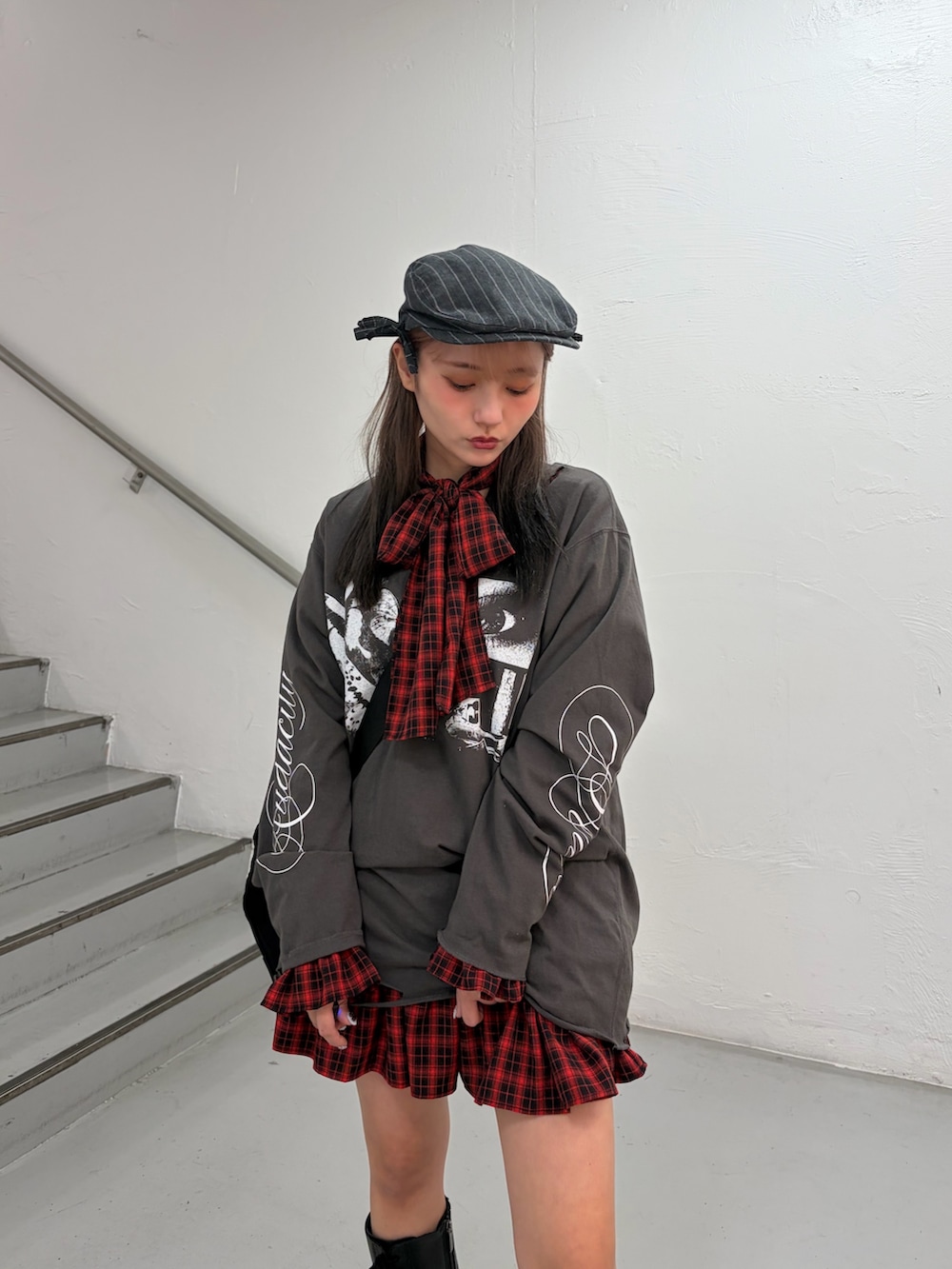 ブラック系のTシャツ/カットソー、レッド系のワンピース、ブラック系のボストンバッグを着用したレディースの冬コーディネートの5枚目の写真