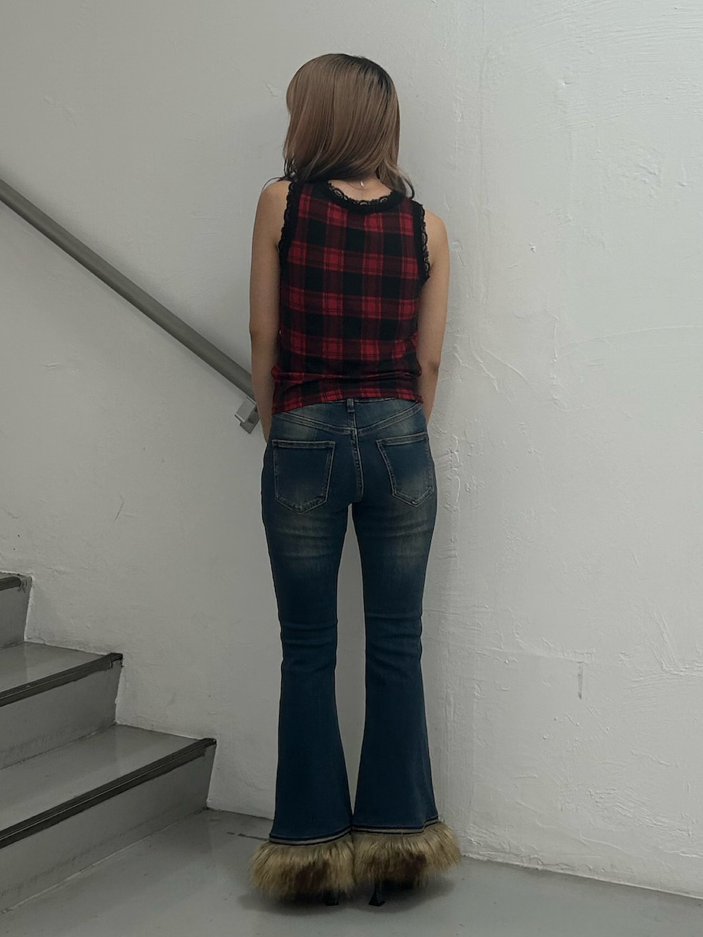 レッド系のタンクトップ、ブルー系のデニムパンツ、シルバー系のネックレスを着用したレディースの夏コーディネートの3枚目の写真