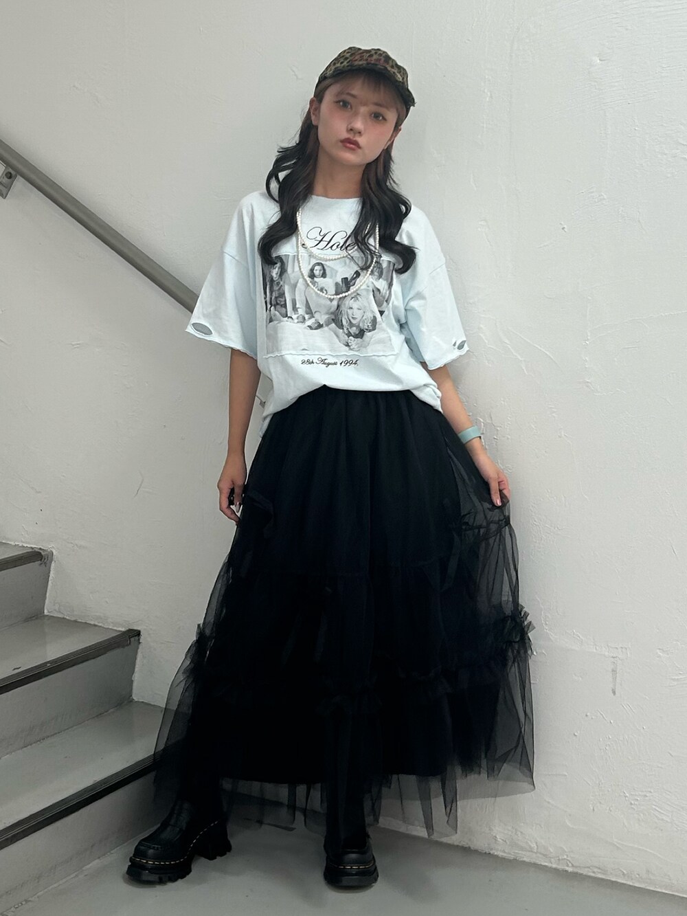 ブルー系のTシャツ/カットソー、ブラック系のスカート、ブラウン系のキャップを着用したレディースの夏コーディネートの2枚目の写真