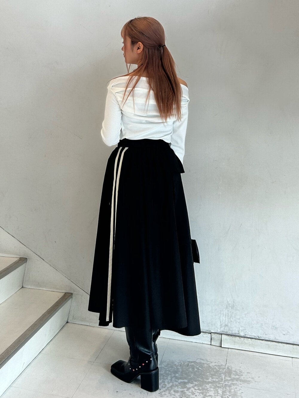 ホワイト系のTシャツ/カットソー、ブラック系のスカート、ブラック系のハンドバッグを着用したレディースの春コーディネートの2枚目の写真