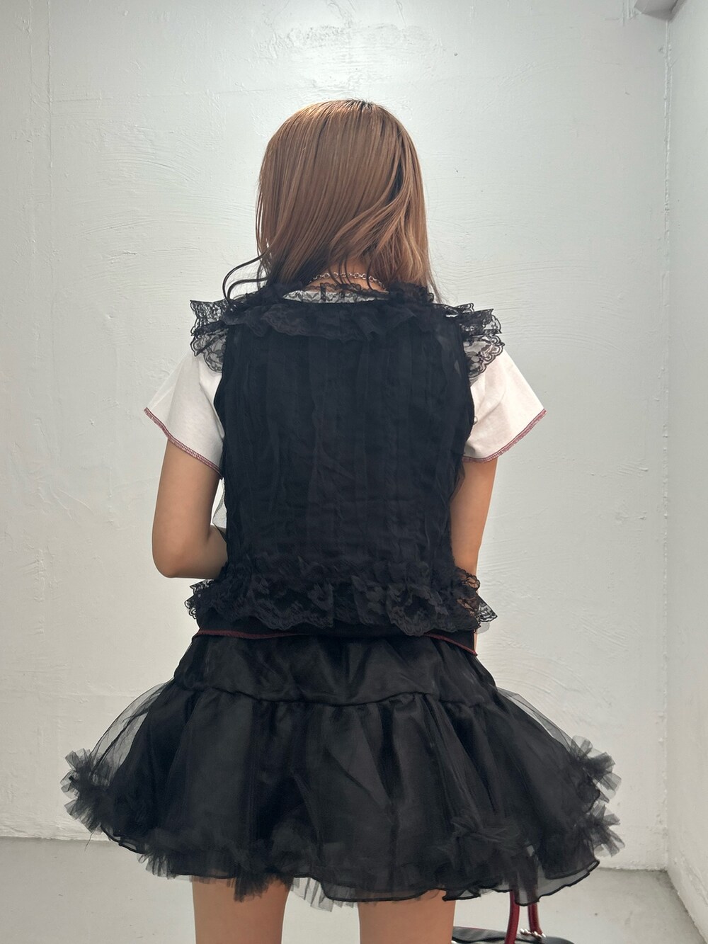 ブラック系のTシャツ/カットソー、ブラック系のスカート、ブラック系のボストンバッグを着用したレディースの夏コーディネートの6枚目の写真