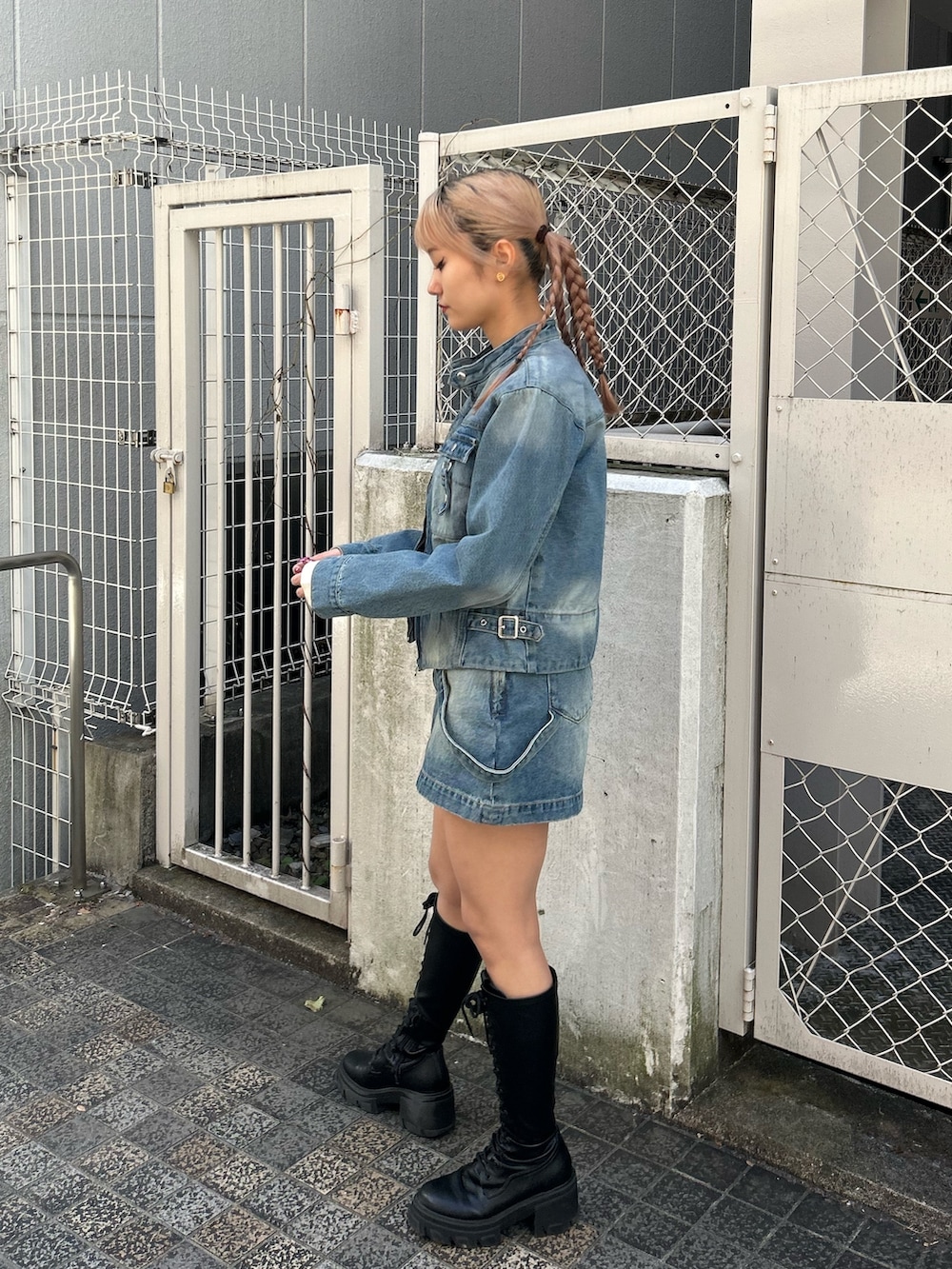 ブルー系のデニムジャケット、ブルー系のデニムスカート、ホワイト系のTシャツ/カットソーを着用したレディースの冬コーディネートの2枚目の写真