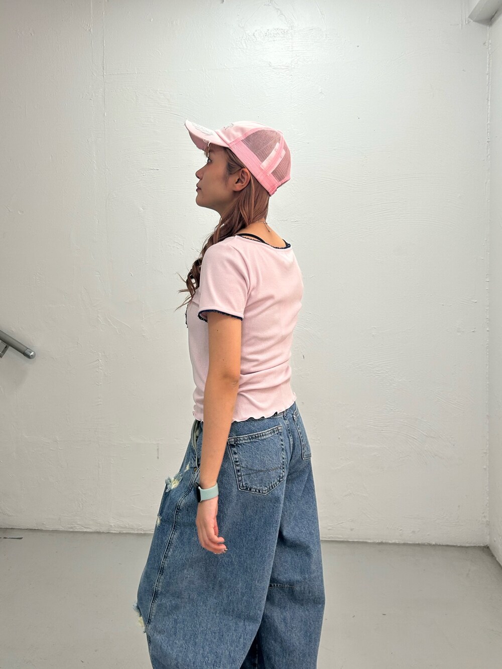 ピンク系のTシャツ/カットソー、ブルー系のデニムパンツ、ピンク系のキャップを着用したレディースの春コーディネートの5枚目の写真