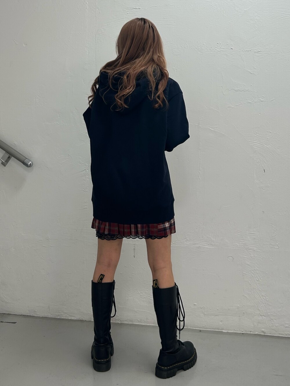 ブルー系のパーカー、レッド系のスカート、ブラック系のチョーカーを着用したレディースの冬コーディネートの3枚目の写真