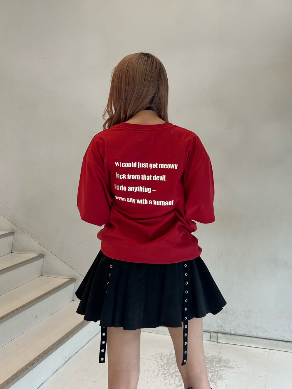 レッド系のTシャツ/カットソー、ブラック系のスカート、ブラック系のチョーカーを着用したレディースの春コーディネートの6枚目の写真