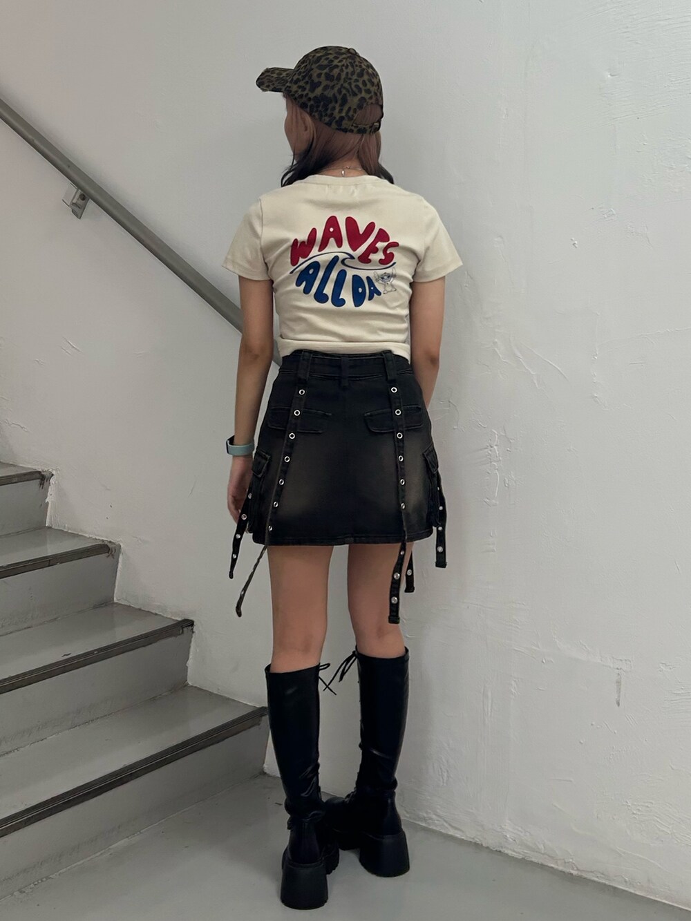 ホワイト系のTシャツ/カットソー、ブラック系のスカート、ブラック系のブーツを着用したレディースの夏コーディネートの3枚目の写真