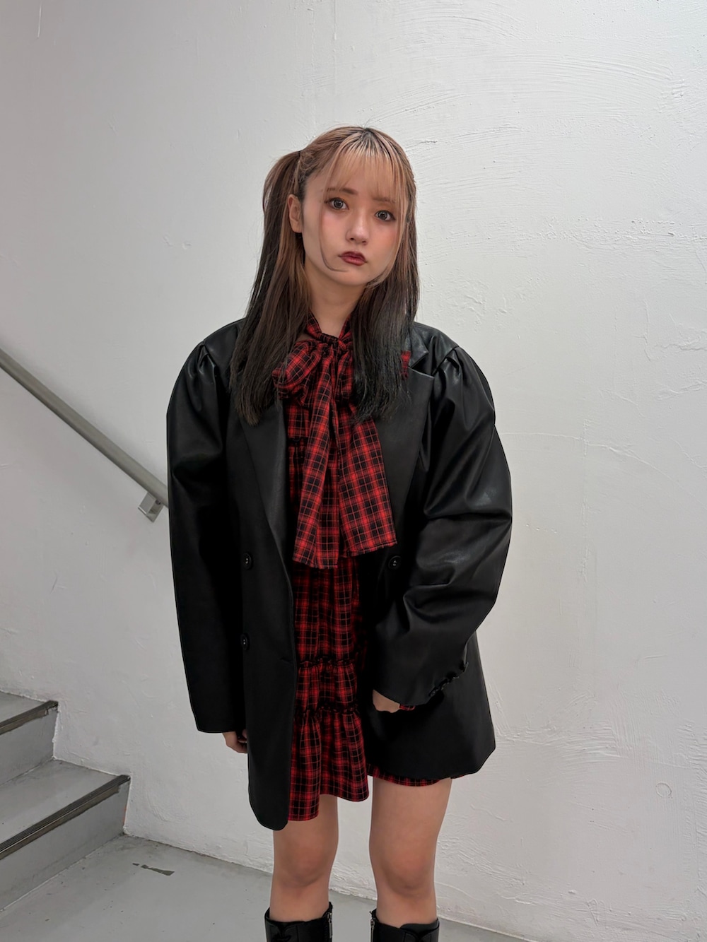 レッド系のワンピース、ブラック系のテーラードジャケットを着用したレディースの春コーディネートの5枚目の写真