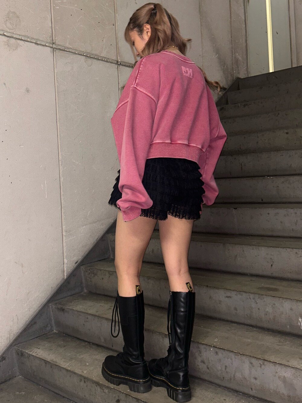 ピンク系のスウェット、ブラック系のその他パンツ、ゴールド系のネックレスを着用したレディースの冬コーディネートの2枚目の写真