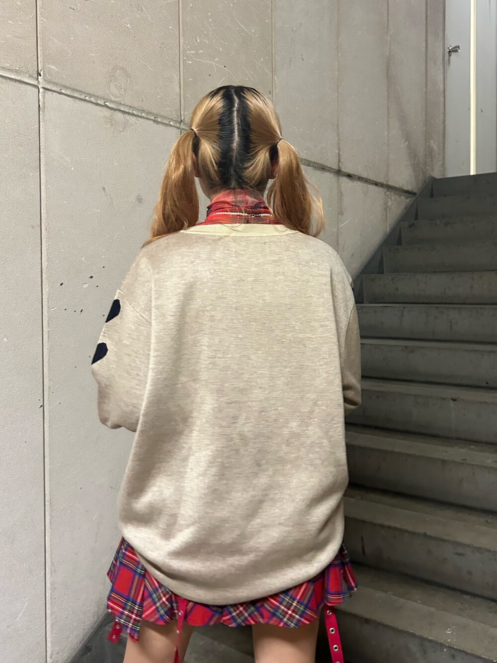 ホワイト系のニット/セーター、レッド系のスカート、レッド系のTシャツ/カットソーを着用したレディースの秋コーディネートの6枚目の写真