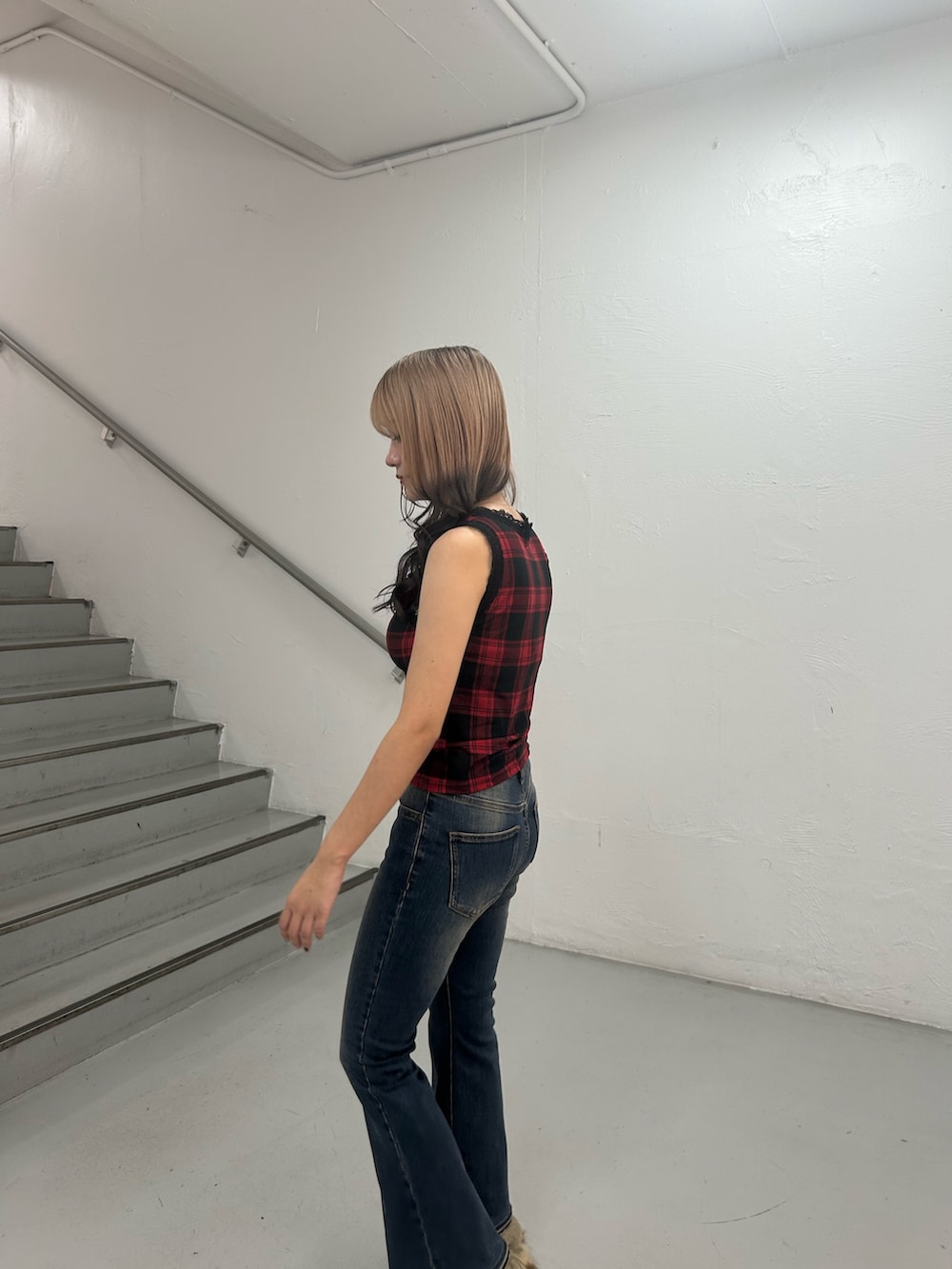 レッド系のタンクトップ、ブルー系のデニムパンツ、シルバー系のネックレスを着用したレディースの夏コーディネートの6枚目の写真