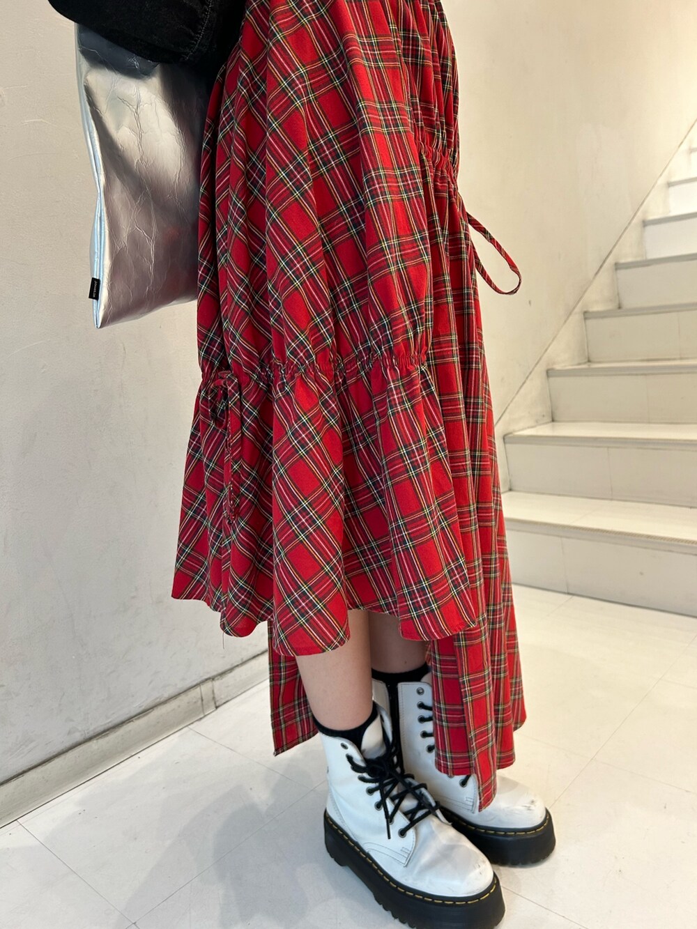 ブラック系のニット/セーター、ブラック系のワンピース、レッド系のスカートを着用したレディースの春コーディネートの8枚目の写真