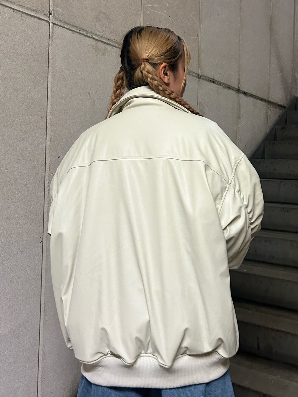 ホワイト系のブルゾン、ピンク系のニット/セーター、ブルー系のデニムパンツを着用したレディースの秋コーディネートの6枚目の写真