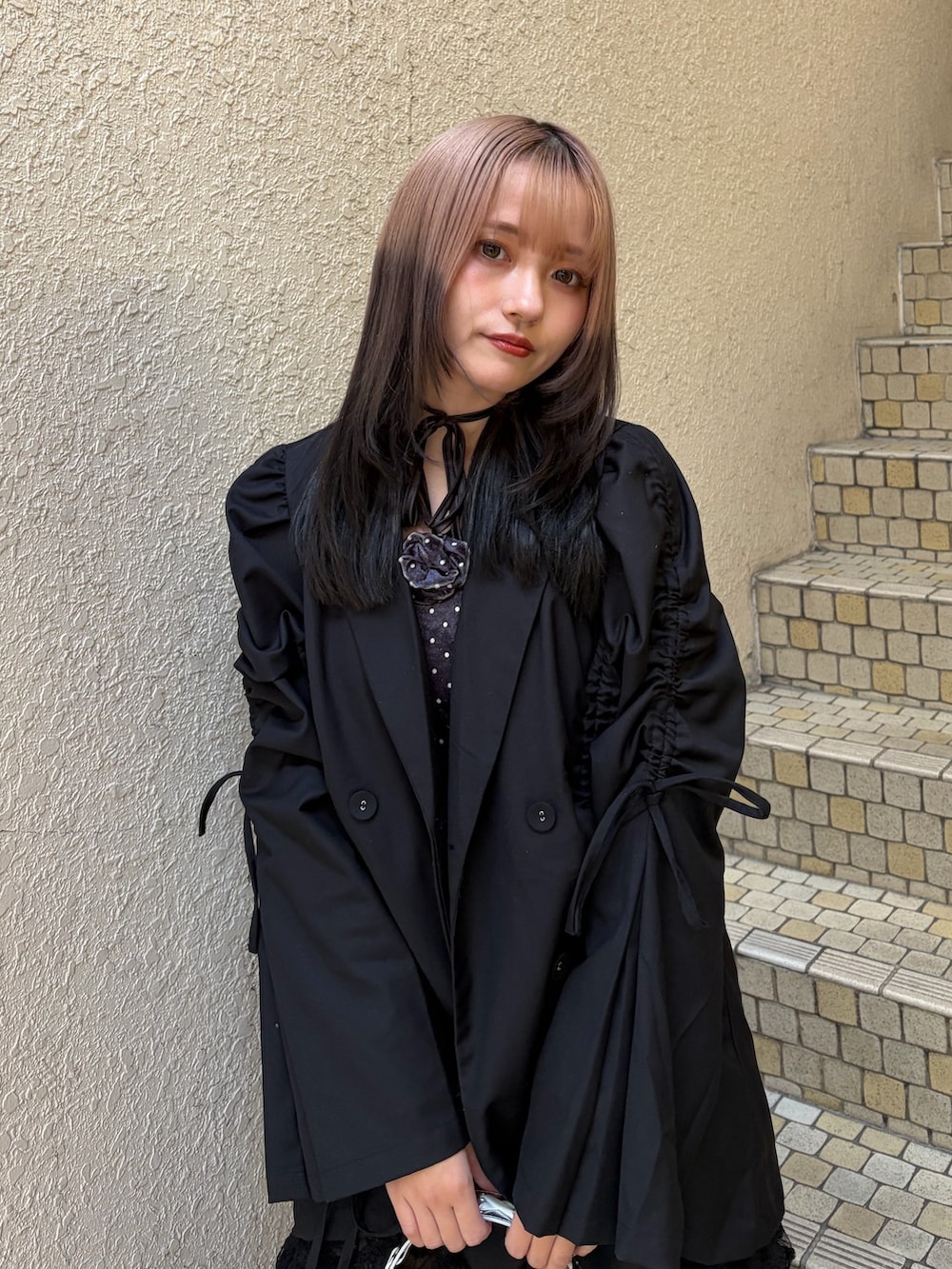 ブラック系のテーラードジャケット、ブラック系のその他パンツ、シルバー系のハンドバッグを着用したレディースの冬コーディネートの4枚目の写真