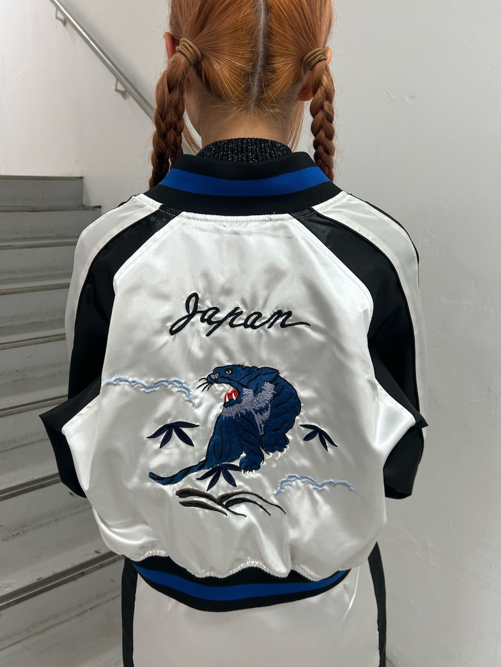 ホワイト系のスカジャン、ブラック系のニット/セーター、ホワイト系のスカートを着用したレディースの春コーディネートの9枚目の写真