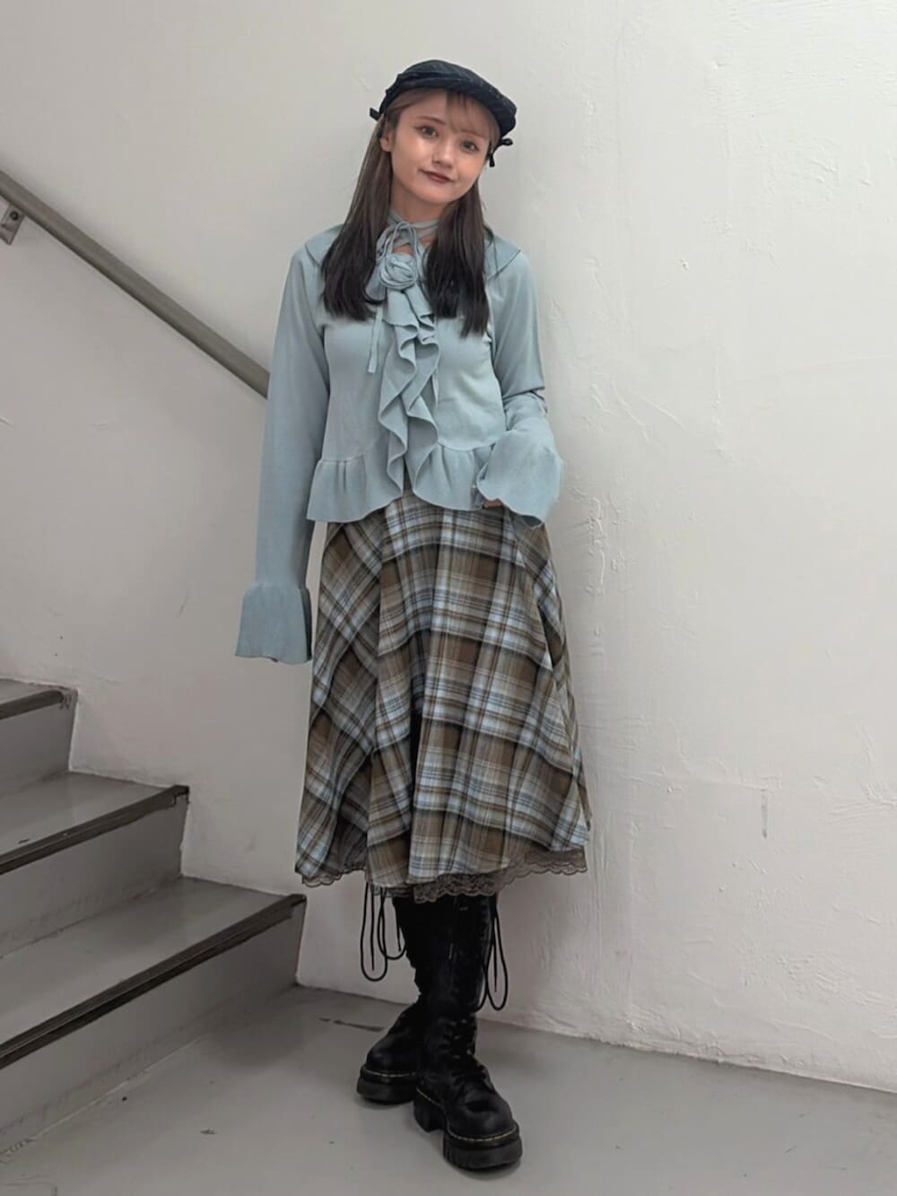 ブラウン系のスカート、ブルー系のニット/セーター、ブルー系のハンチング/ベレー帽を着用したレディースの冬コーディネートの2枚目の写真