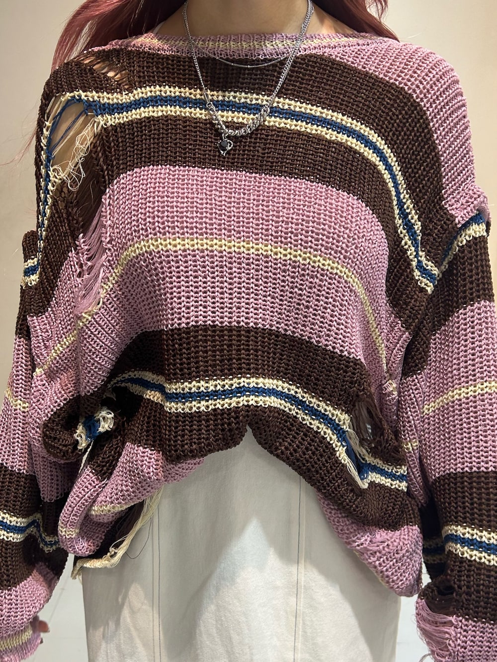 ピンク系のニット/セーター、ホワイト系のワンピース、ブラック系のブーツを着用したレディースの春コーディネートの7枚目の写真