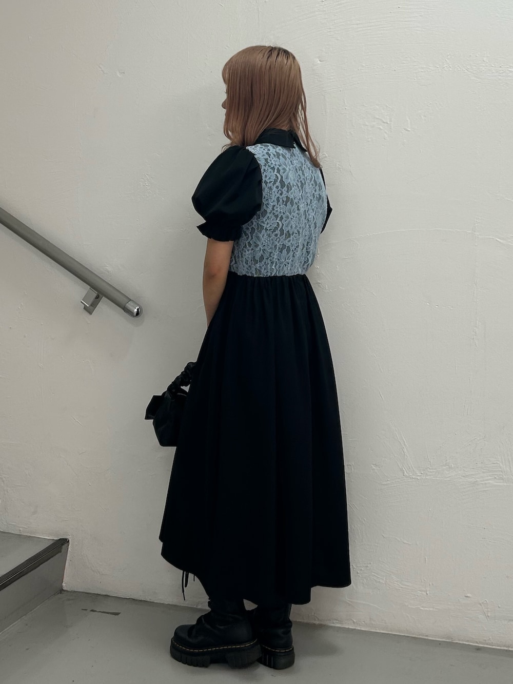 ブラック系のワンピース、ブラック系のハンドバッグ、シルバー系のブレスレットを着用したレディースの春コーディネートの2枚目の写真