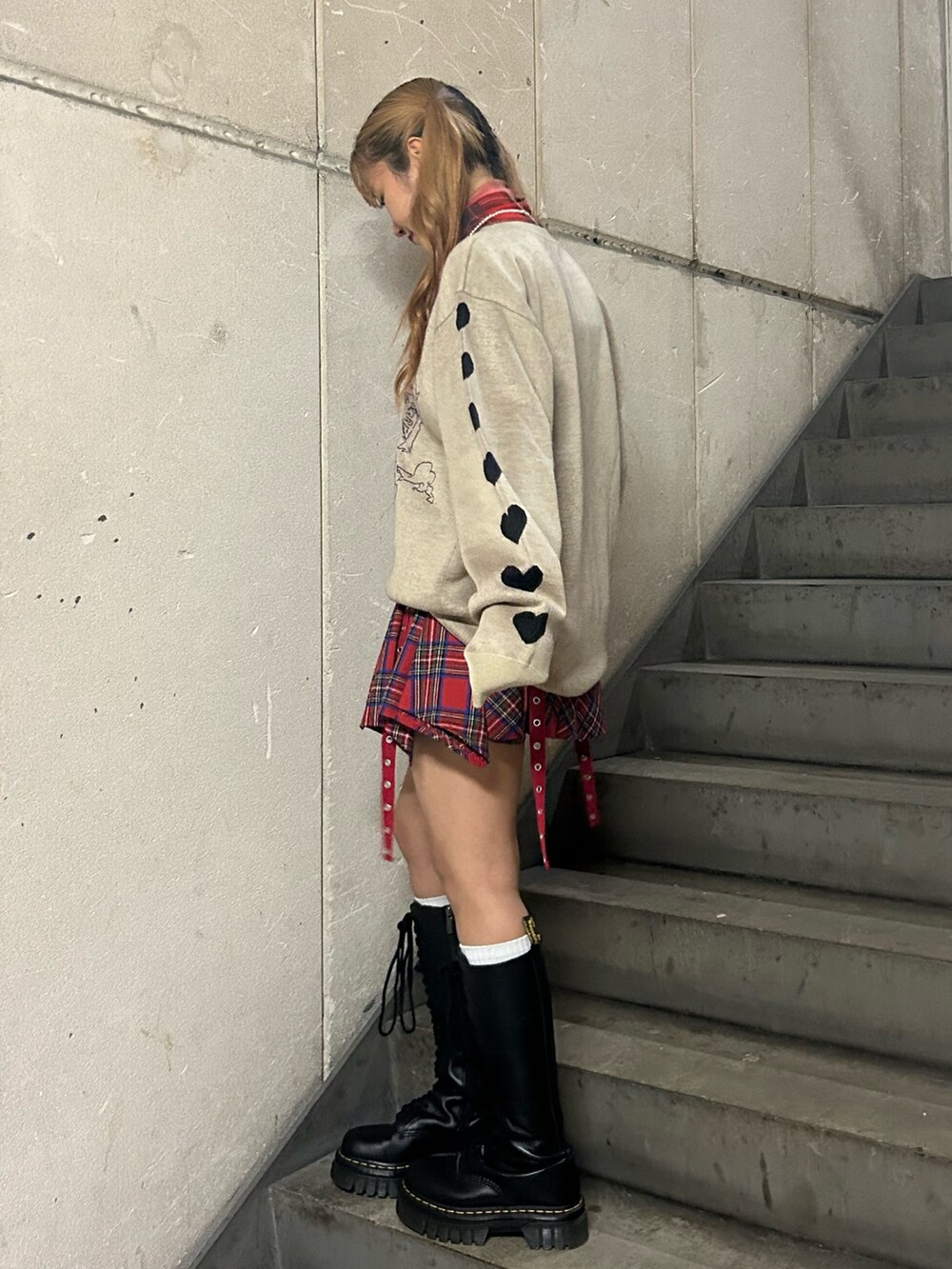 ホワイト系のニット/セーター、レッド系のスカート、レッド系のTシャツ/カットソーを着用したレディースの秋コーディネートの2枚目の写真