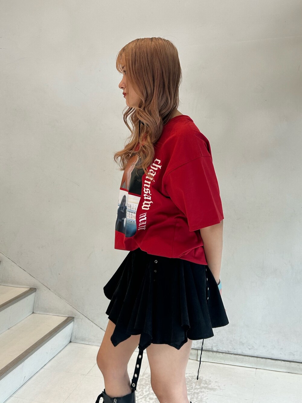 レッド系のTシャツ/カットソー、ブラック系のスカート、ブラック系のチョーカーを着用したレディースの春コーディネートの5枚目の写真