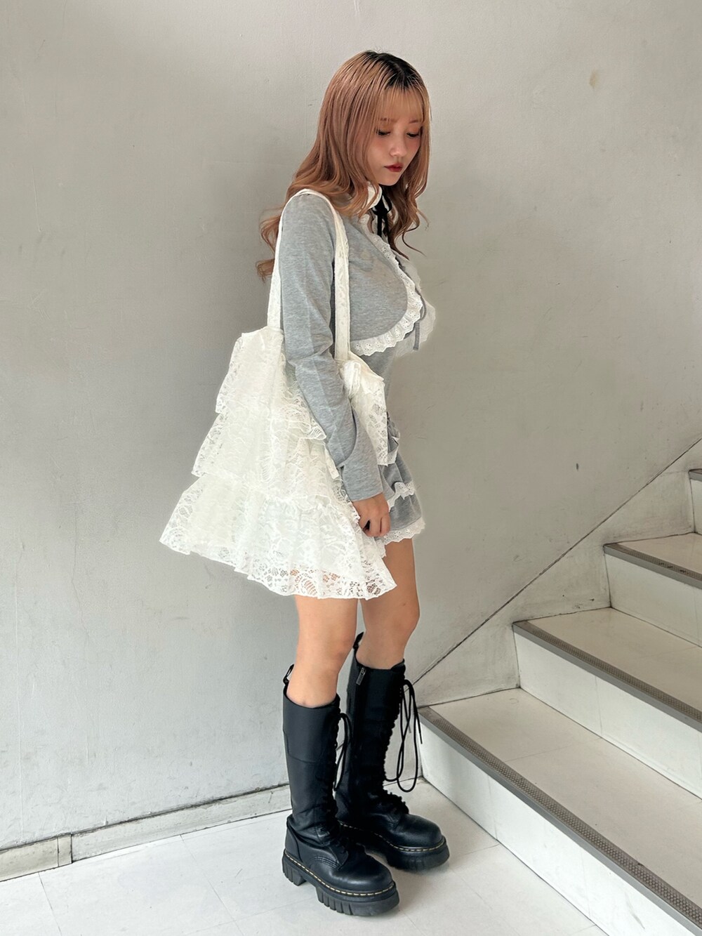 グレー系のワンピース、ホワイト系のトートバッグ、ホワイト系のチョーカーを着用したレディースの春コーディネートの3枚目の写真