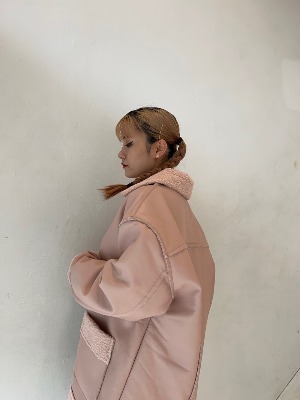 ピンク系のムートンコート、ホワイト系のスウェット、ブラック系のブーツを着用したレディースの秋コーディネートの5枚目の写真