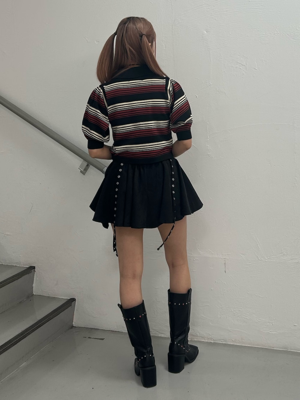 ブラック系のニット/セーター、ブラック系のスカート、ブラック系のブーツを着用したレディースの春コーディネートの3枚目の写真