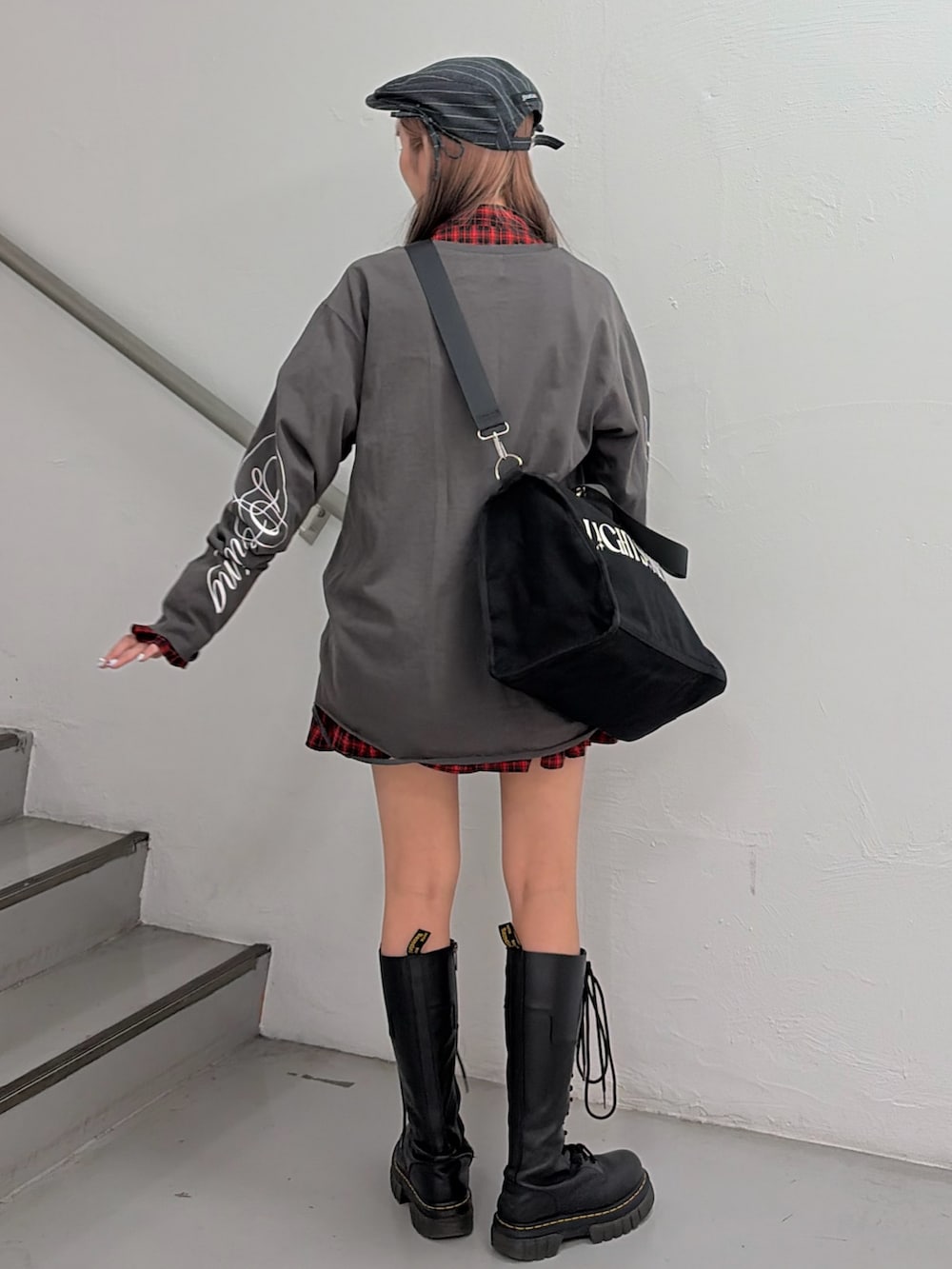 ブラック系のTシャツ/カットソー、レッド系のワンピース、ブラック系のボストンバッグを着用したレディースの冬コーディネートの3枚目の写真