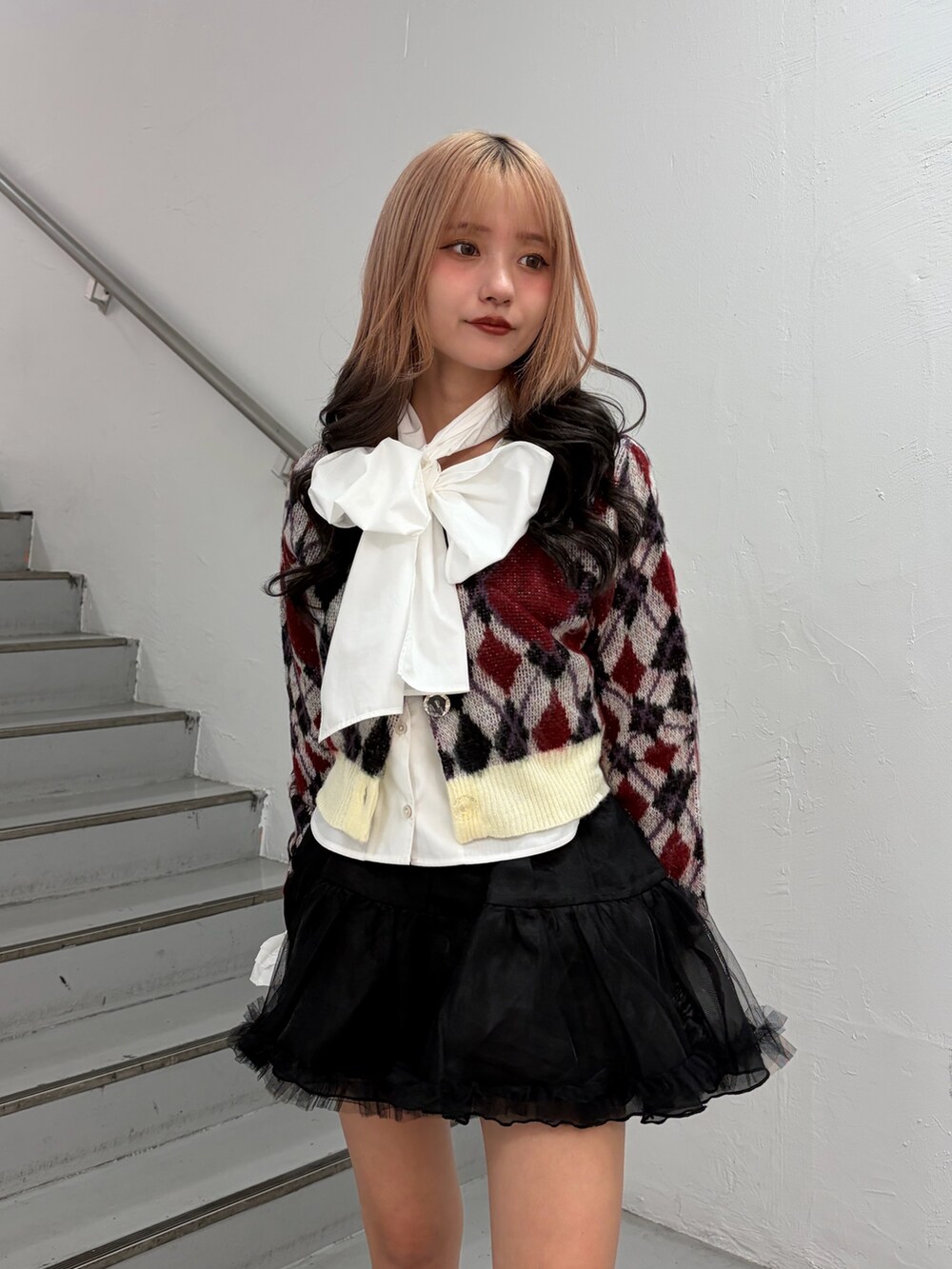 ホワイト系のカーディガン/ボレロ、ホワイト系のシャツ/ブラウス、ブラック系のスカートを着用したレディースの秋コーディネートの4枚目の写真