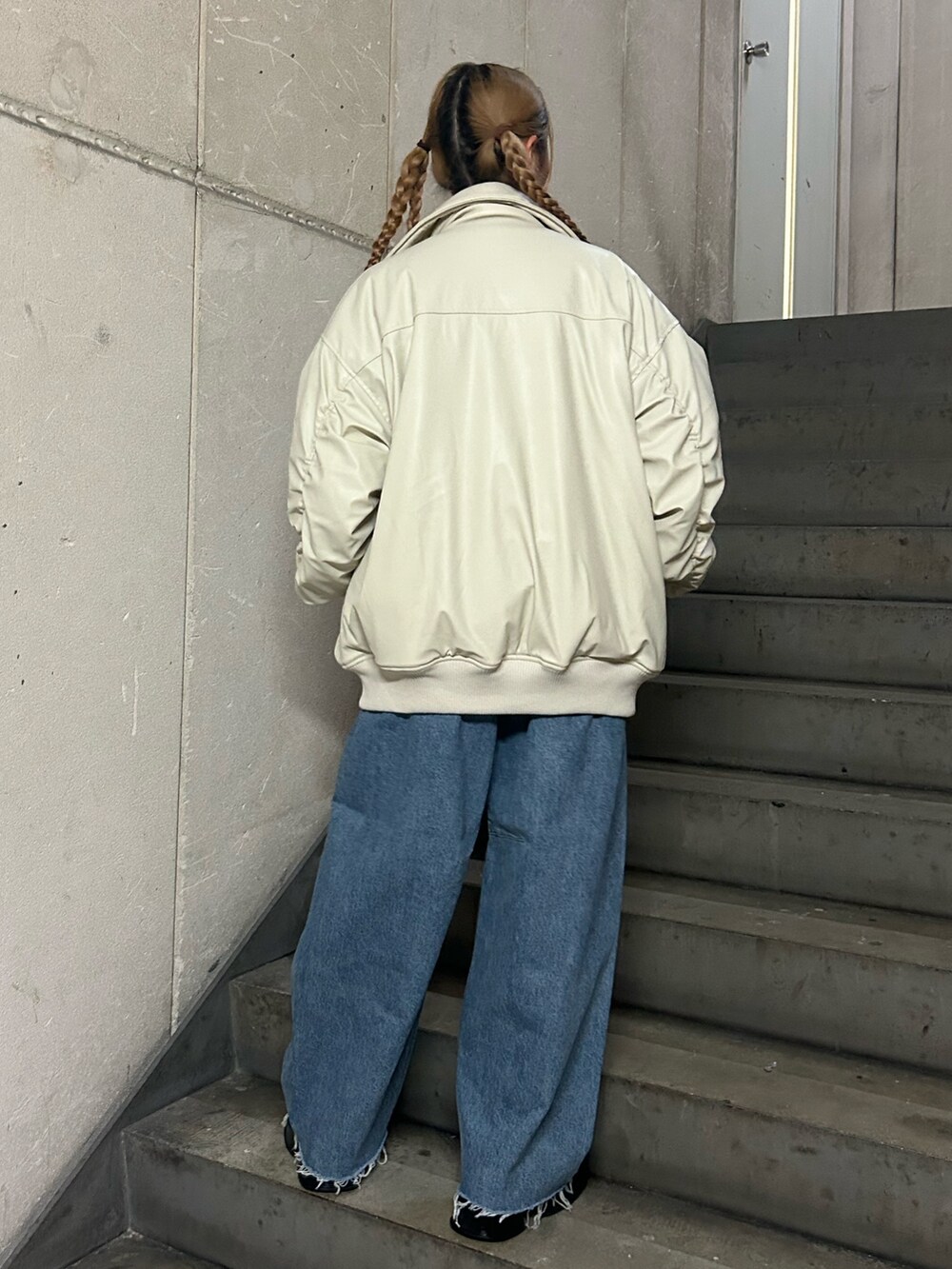 ホワイト系のブルゾン、ピンク系のニット/セーター、ブルー系のデニムパンツを着用したレディースの秋コーディネートの3枚目の写真