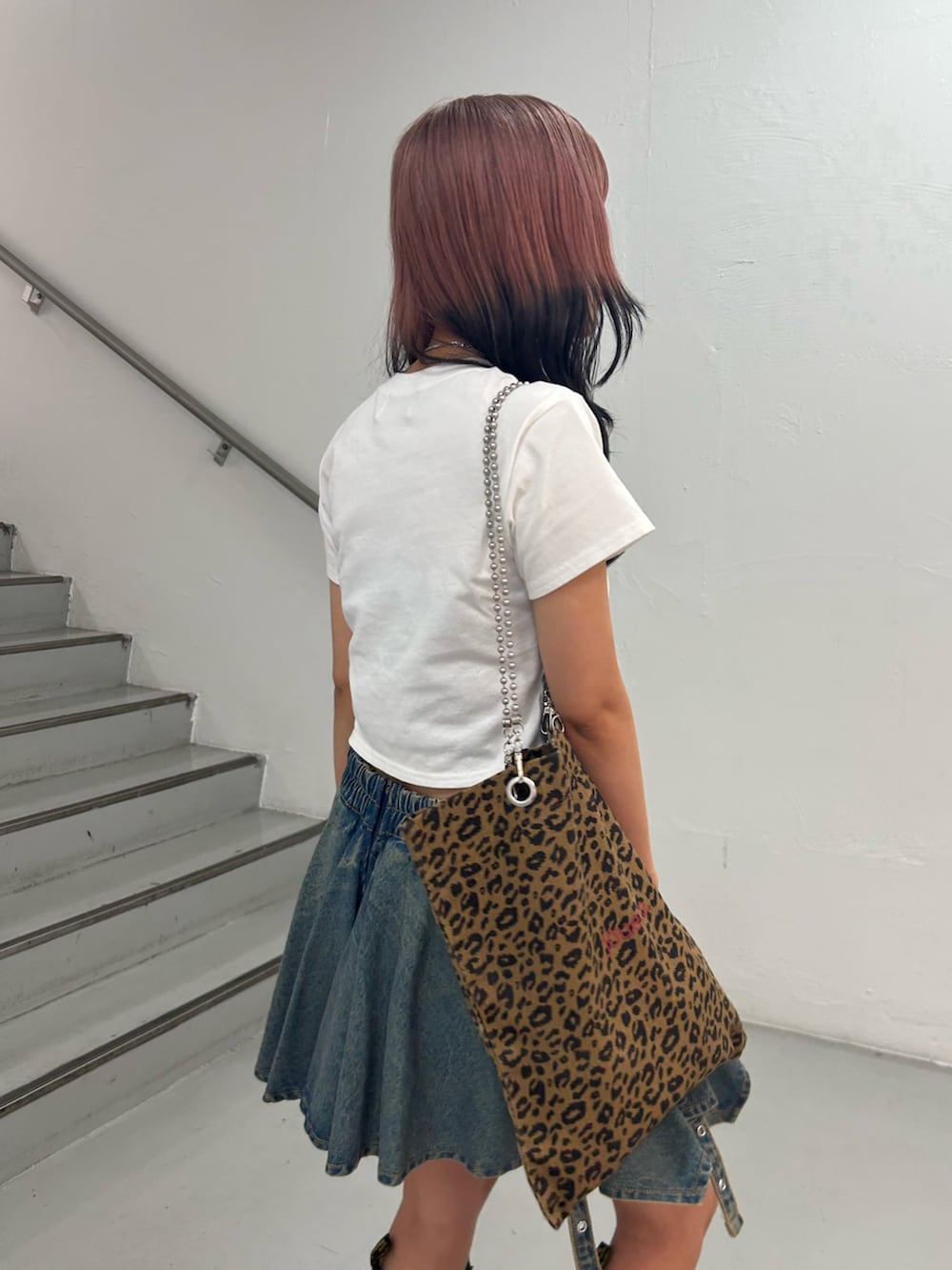 ホワイト系のTシャツ/カットソー、ブルー系のデニムスカート、ブラウン系のトートバッグを着用したレディースの夏コーディネートの5枚目の写真