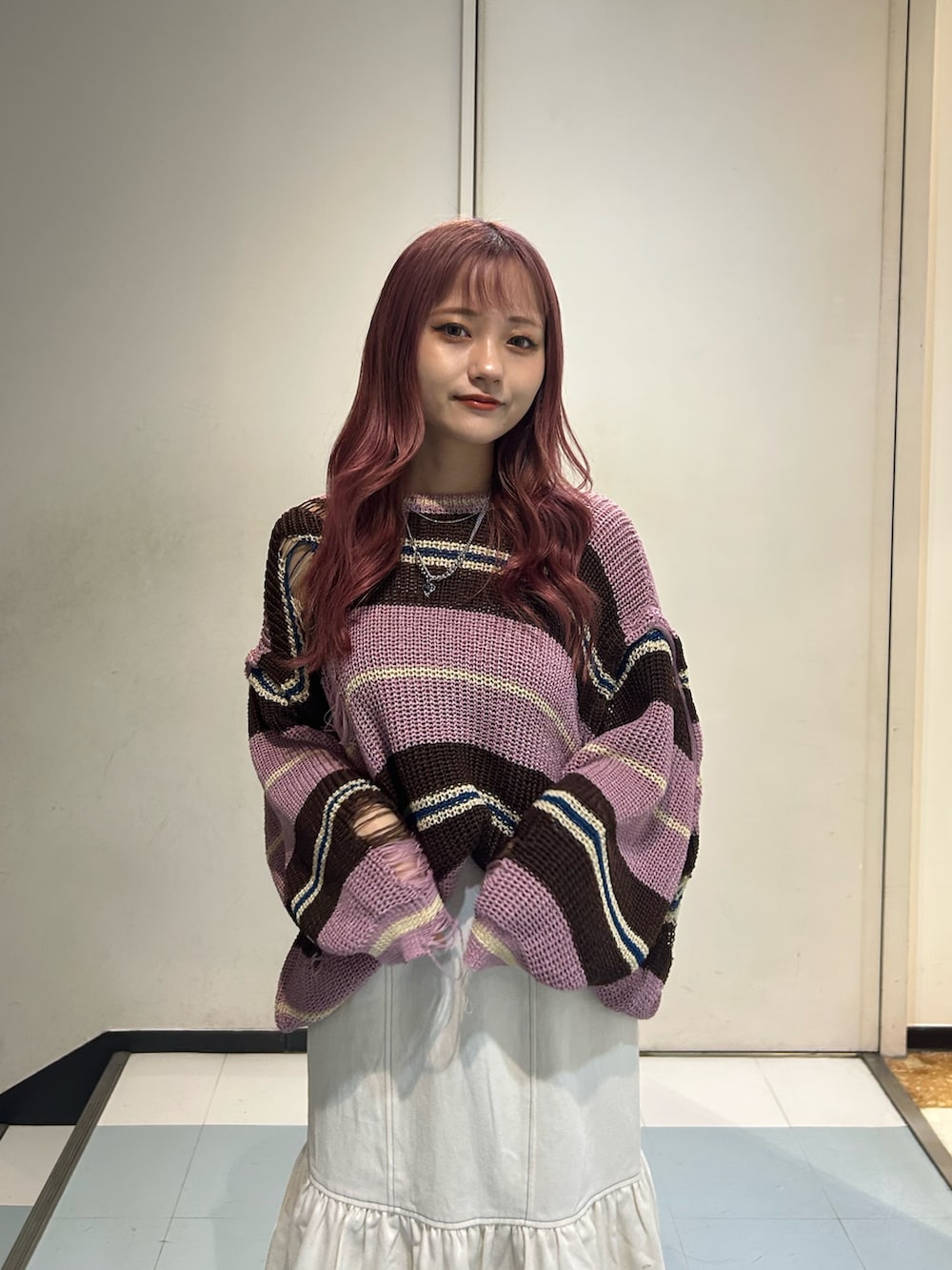 ピンク系のニット/セーター、ホワイト系のワンピース、ブラック系のブーツを着用したレディースの春コーディネートの4枚目の写真