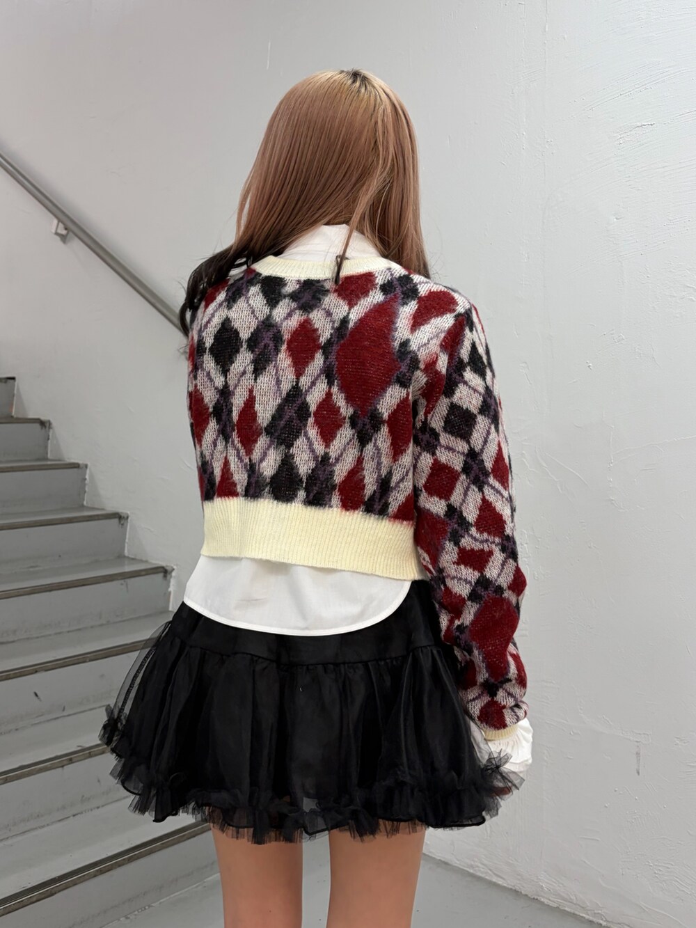 ホワイト系のカーディガン/ボレロ、ホワイト系のシャツ/ブラウス、ブラック系のスカートを着用したレディースの秋コーディネートの6枚目の写真