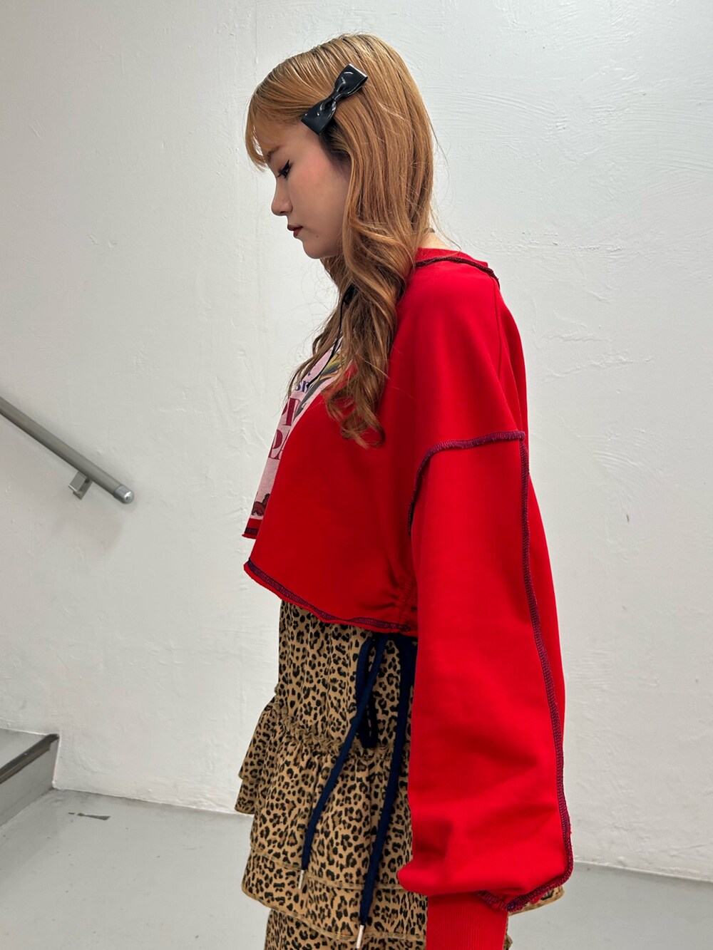 レッド系のスウェット、ブラウン系のスカート、ブラック系のバレエシューズを着用したレディースの夏コーディネートの5枚目の写真