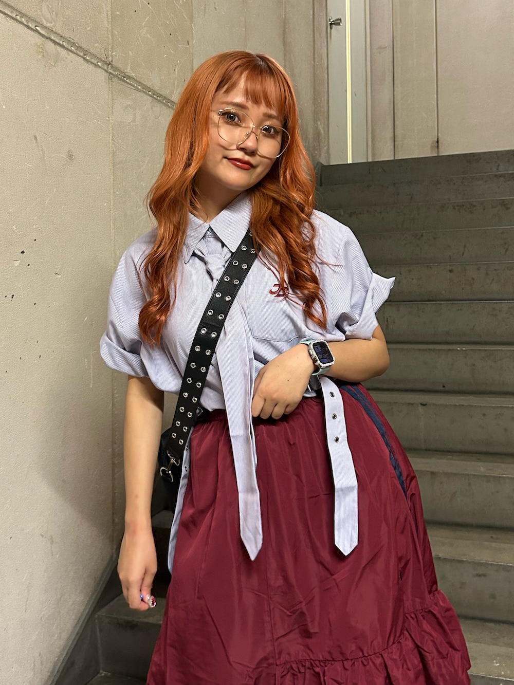 パープル系のシャツ/ブラウス、レッド系のスカート、ブラック系のショルダーバッグを着用したレディースの夏コーディネートの4枚目の写真