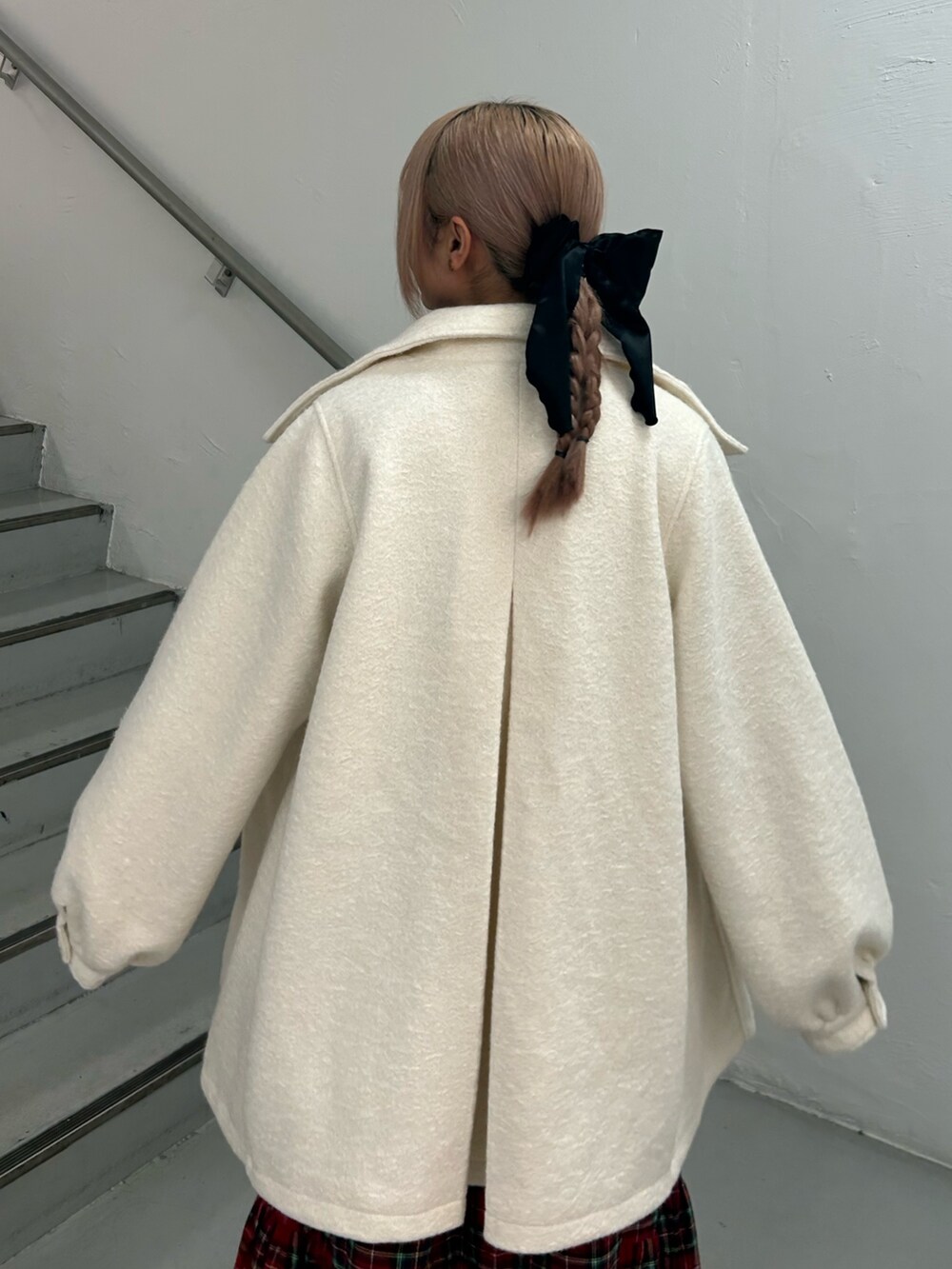 レッド系のワンピース、ホワイト系のその他アウター、ブラック系のバレッタ/ヘアクリップを着用したレディースの冬コーディネートの6枚目の写真