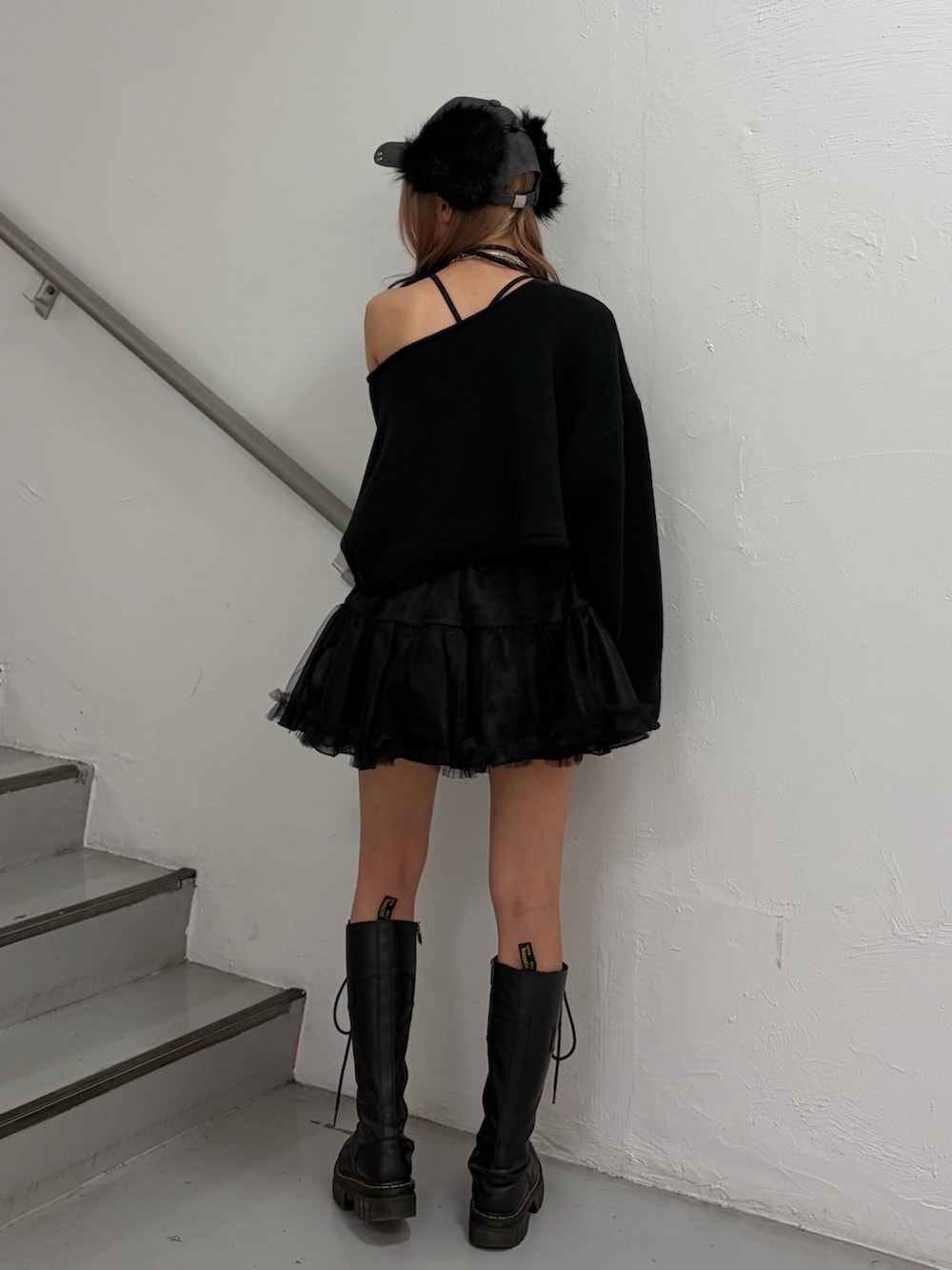 ブラック系のニット/セーター、ブラック系のスカート、ブラック系のキャップを着用したレディースの秋コーディネートの4枚目の写真