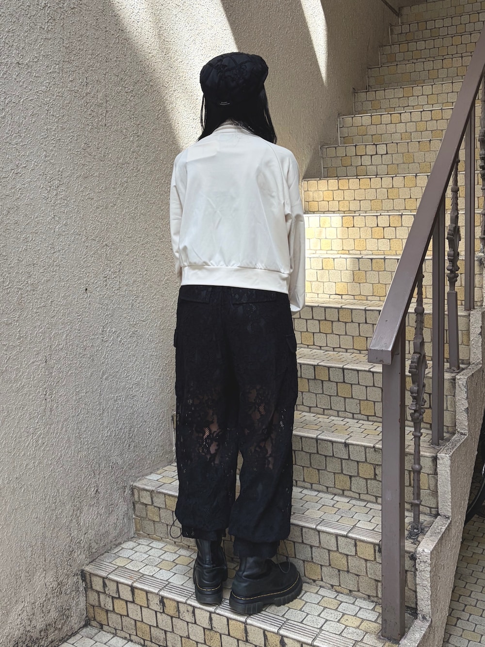 ホワイト系のTシャツ/カットソー、ブラック系のその他パンツ、ブラウン系のハンドバッグを着用したレディースの夏コーディネートの2枚目の写真